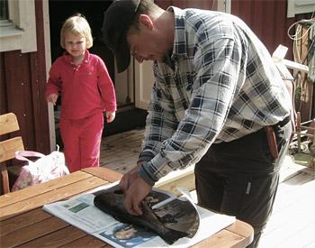 Igor rensar fisk. Maya tittar på.